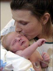 Crystal Turner gave birth to her son Toby Keith Collins at 1:30
p.m. Thursday in the company of her 1- and 2-year-old daughters in
her Baldwin home. Turner, 30, didn't have time to get to the
hospital in the 15-minute window between when her water broke and
when she gave birth. She tied the umbilical cord herself using a
string and a bread bag tie. Her two other children, a 5-year-old
and an 11-year-old, were at school. She is pictured Thursday at
Lawrence Memorial Hospital, where she arrived a few hours after
giving birth. Turner was released Thursday evening.