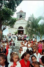 A long-standing embargo against Cuba -- imposed in the early 1960s
after the communist government expropriated American companies and
other property on the island -- is intended to punish President
Fidel Castro's regime while showing support for the people of Cuba.
Here, a crowd of Cubans surround a church.