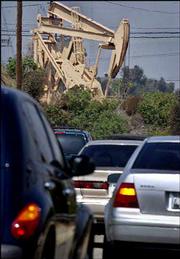 Traffic passes operating pumps at the Inglewood Oil Field in Los
Angeles County. As Americans face high oil and gasoline prices,
OPEC announced Wednesday that it would cut its crude oil
production.