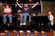 Kansas University fans Jan Howard, left, Lecompton, and Charlie
Parnell, Kansas City, Kan., lead a sing-along in St. Louis. They
attended a pre-game pep rally March 26 at the Big Bang Bar in St.
Louis. They were in St. Louis to cheer on the Jayhawk's men's
basketball team during the NCAA Tournament. The piano player is Sam
Leatherwood.