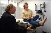 Dr. Vern Cherewatenko treats patient Angela Wilhelm in Renton,
Wash. Cherewatenko is one of a small but growing number of
physicians who are eliminating insurance contracts in favor of
cash-only payments.