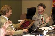 Newly installed mayor Mike Rundle, right, applauds outgoing mayor
David Dunfield after presenting him with a gavel. Rundle took over
as Lawrence mayor at Tuesday's City Commission meeting.