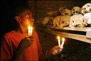 Apollan Odetta, a survivor of the 1994 Rwandan genocide, lights
candles at a mass grave in Nyamata, Rwanda. Rwanda today is
observing the 10th anniversary of the genocide that began April 7,
1994. Some 500,000 people died in the 100-day killing spree.