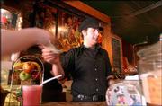 Ryan Folker, a barista at Henry&squot;s, 11 E. Eighth St., prepares a
drink for a customer at the coffee shop. The business allows
smoking, and Folker said he thought that businesses should be able
to choose whether to be smoker-friendly or smoke-free. Folker, who
smokes, added, "I&squot;d feel the same way if I wasn&squot;t a smoker." He was
working Tuesday at Henry&squot;s.