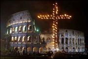 An 18-foot cross dominates the Way of the Cross torchlight
procession attended by Pope John Paul II on Good Friday in Rome.
Many faithful stood under umbrellas in pouring rain for hours to
get a good view of the procession. The rain stopped shortly before
the pope arrived at the Colosseum. Among the procession
participants was a young woman from Madrid, included as a sign of
solidarity with Spain after the deadly March 11 train bombings
there.