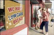 Great Harvest Bread Co. baker Bri Hickman holds the door for Holly
Stegall and her son William, 3. Last week, they entered the
downtown bakery which offers low-carbohydrate bread. The store
sells about 20 loaves of the low-carb offering a day.