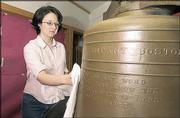 Lawrence High School senior Karen Bently cleans a historic bell as
part of a project to refurbish and display the artifact this fall
at LHS to commemorate Lawrence's 150th birthday. The bell weighs
1,600 pounds.