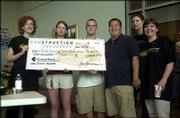 Jane Hemenway, left, presents a $200 check to the "best of show"
winners of the Canstruction contest. Members of the winning group
were, second from left, Meredith VanLoenen, Chris Berger and Jack
Low, of Trinity Episcopal Church Youth Group, and Theresa Roach and
Donna Griffin, of Gould Evans Associates. The fund-raising event
was last Saturday at CornerBank in Lawrence. It raised money for
youth groups and helped fill Lawrence food pantries. The group
designed a Jamaican flag using canned goods.