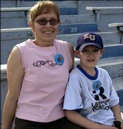 Carrie Mayhew, Lawrence, and her son Thomas, 7, watch the Kansas
University Relays. They attended the event last Saturday at
Memorial Stadium.