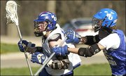 Kansas University junior Nate Macon, left, of the KU Men's Lacrosse
Club, tries to get an open shot as freshman Matt Elder roughs him
up a bit.