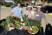 Lawrence Farmers Market employees prepare for its opening on
Saturday in the 1000 block of Vermont Street. Pictured Thursday
are, from left, Jake Jones, intern for the market; Barbara Clark,
chairwoman of the market's board of directors; and Emily Miller,
market coordinator.