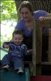 Erica Wilcoxson, Lawrence, helps her son Avery, 1, go down the
slide during the Red School Rockin' Jamboree at the Lawrence
Community Nursery School. Last Saturday's event, which included
live music, food and games, was a fund-raiser for the school.