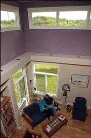 Vaulted ceilings lend a loft-like feel to the living room while
expansive windows fill Louis and Phyliss Copt's home with natural
light.
