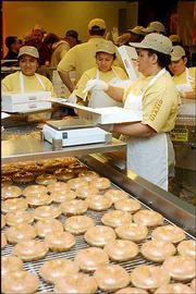 Employees of Krispy Kreme box dozens of glazed doughnuts for
customers during the store's grand opening Feb. 17 in Little Rock,
Ark. The company announced last week that profits were expected to
drop 10 percent this year. It blamed the decrease on the low-carb
diet craze, but analysts say the firm's rapid expansion also has
hurt business.
