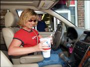Angela Muggenburg gets her lunch at a drive-through McDonald's in
Springfield, Mo. The busy mom is one among many Americans whose
chaotic schedules have them picking up more than an occasional meal
to eat on the go.