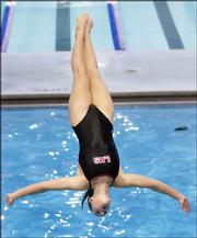 Lawrence High senior Ellie Lloyd performs a reverse dive. Lloyd
placed 13th in diving competition Saturday in Manhattan.
