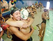 Free State High sophomore Ashley Robinson, left, hugs Wichita
Trinity's Caroline Bruce after Robinson won the 500-yard freestyle
at the Kansas state swimming and diving championships. Robinson
also won the 100 butterfly Saturday in Manhattan.