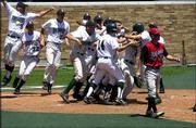 The Free State High baseball team celebrates its extra-inning
victory over Blue Valley West. The Firebirds' 3-2, eight-inning win
Friday at Hoglund Ballpark advanced FSHS to the Class 6A state
semifinals. BV West pitcher Lance Hoge is at right.