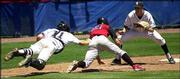 Free State High catcher Ryne Price, left, tags out a Blue Valley
West runner during a rundown between third base and home. Free
State's Cory Cooper is at right.