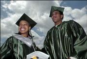 Free State High School seniors Kamesha Moore, left, and Tyree Payne
participate in the Class of 2004 commencement ceremony. They
received their diplomas May 15 during the ceremony at Kansas
University's Memorial Stadium.