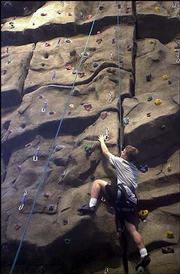 JOSH WICOFF, a Kansas University sophomore from Lenexa, climbs the
rock wall in the Student Recreation Fitness Center. The center
opened in September 2003.