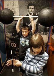 Ryan Arndt, back, and Katie Zynda play with some props in the
Houdini exhibit at the Outagamie Museum in Appleton, Wis. Magicians
are taking sides over a revamped exhibit on illusionist Harry
Houdini that reveals the secret behind one of his signature tricks.
The museum opened "A.K.A. Houdini" Wednesday for a 10-year run to
honor Houdini, who considered Appleton his hometown.