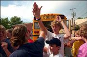 Kirby Beneventi, 19, left, high-fives Chase Hoag, 13, after Hoag
and other members of the First Christian Church Youth Group arrive
in Lawrence after having been stuck since last Friday in Colorado.
Beneventi was also with the group but got a ride home on Saturday.
The school bus with the rest of the youth group returned Thursday
afternoon. In foreground at bottom is youth group member Zach
"Chewey" Canote, 12.