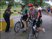 Doug Hitt, Lecompton, center, shows a security guard a photo ID to
gain entrance to Fort Riley. Cyclists with Bike Across Kansas were
allowed access through the historic section on their route from
Chapman to St. Marys.