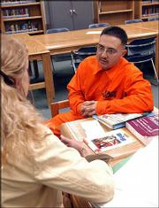 Tomas Villareal, right, a prisoner at the Penitentiary of New
Mexico, talks with Melody Whitehead, left, transition coordinator
for the Education Department at the penitentiary. Whitehead runs
two programs that help Villareal stay in touch with his children
and learn to be a better father.