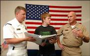 U.S. Navy recruiters Rob Parsons, left, and Dave Iltzsch, right,
talk with Andy Lowder 17, a 2004 Lawrence High School graduate,
about the options in the Navy. Lowder was checking out education
prospects and job possibilities that come with military service.