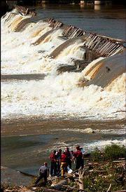 Emergency officials from Lawrence and Douglas County examine a body
found just below the Bowersock Dam. Family members said the body,
which surfaced Wednesday morning in the Kansas River, was that of
52-year-old Robert Lathrom, of rural Oskaloosa, who was reported
missing Monday.