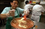 Alma Quintanilla mixes garlic powder into a bowl of salsa for this
weekend's Fiesta Mexicana at St. John the Evangelist Catholic
Church 1234 Ky. Quintanilla and others cooked Wednesday.