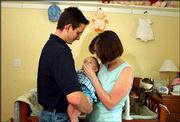 Lawrence residents Nathan and Jessica Fortner cuddle their
7-month-old daughter, Eliza Mae. The infant is regaining strength
after two recent surgeries to diagnose and treat symptoms of a
brain tumor.