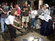 Phil Ostronic, of Lawrence, pleads with Eugenia Harte, of
Lexington, Mo., to not dump alcohol at Free State Brewing Co.
during the Chautauqua Temperance Rally. Re-enactors made their way
down Massachusetts Street pleading with residents Friday to give up
their grog.