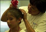Sarah Chavez, 10, gets a helping hand with a hair accessory from
her mother, before going on stage at the 23rd annual St. John's
Mexican Fiesta. Friday night's events included dancing, music and
authentic Mexican food. The Fiesta continues at 5:30 tonight on the
grounds at St. John the Evangelist Catholic Church, 1234 Ky.