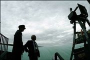 Officials check the sky at court eighteen as rain delayed the start
of play. After the second all-day rainout Saturday, organizers
decided to forgo the traditional day of rest on the middle Sunday
of the All England Lawn Tennis Championships and will have matches
today in Wimbledon, England.