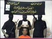 This is an image taken from footage by pan-Arab TV channel
Aljazeera purporting to show armed men reading a statement with a
Filipino hostage. The Aljazeera newscaster said the group offered
to release the hostage if the Philippines withdraws its troops from
Iraq within 72 hours.