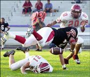 West running back Michael Ball loses control of the ball after a
hit from East's Justin LittleSun (21) during the first half. East's
Micah Swimmer is to the right.
