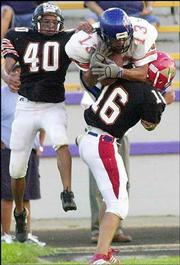 The East's Hunter Smith makes an acrobatic catch for 29 yards while
being covered by West's Trevor Beaver (40) and Michael Watson (16).
The East won the Native American All-Star Football Game, 34-7, on
Saturday night at Haskell Stadium.