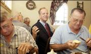 During lunch at the Johnson City Rotary Club, where he was
speaking, Rep. Jerry Moran answers a question asked by Bill Seyb at
the next table. Farmer Earl Arnold is seated, left, and Mayor
Cortland Wartman Jr. is at the right.