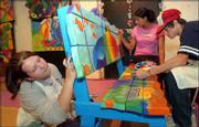 From left, Becca Bost, 15, Zayna Robles, 14, and John Marino, 15,
paint a bench for the Clinton Lake Marina Thursday afternoon.