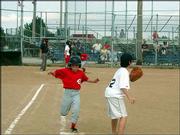 Reds player Ryan Gleue makes it it to first base safely while Nat
Caron covers the bag during a Jhawk Baseball League game against
the Red Sox July 22 at Holcom. The Reds won the game 13-7.