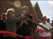Cindy Yulich and Dave Adams, of Emprise Bank, cut a ribbon at a
ceremony marking the opening of the bank's new area headquarters at
1121 Wakarusa Drive. The bank celebrated the opening of its new
location with a ribbon-cutting ceremony and reception on July 16.