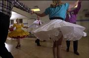 A frilly skirt frames two dancers during the monthly square dance
presented by the Tons of Fun square dancing club. Tons of Fun, the
only square dancing group in Lawrence, will start a new session of
free lessons Aug. 9.