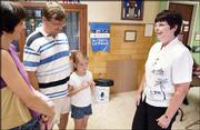 New York School Principal Nancy DeGarmo, right, talks with
Christine and Vance White about their daughter Caroline, 6, an
incoming first-grader, during enrollment. Caroline enrolled on
Wednesday. DeGarmo is one of three new principals this year in the
Lawrence school district.