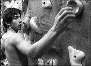 Jonathon Wilde, Kansas University sophomore from Quito, Ecuador,
reaches for a handle while climbing the rock wall at the Student
Recreation Fitness Center. The center will mark its one-year
anniversary this fall.