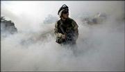 Spc. Jeffrey Ward, from Arlington Va., a medic with the U.S. Army's
1st Cavalry Division, 1st Brigade, 1-12 Cavalry from Fort Hood,
Texas, stands guard in a haze of smoke outside a building in Sadr
City, Iraq. Renewed fighting Sunday in Iraq angered delegates of a
national democracy conference in Baghdad, prompting some to condemn
the United States.