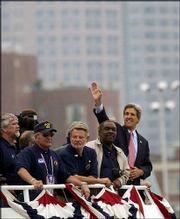 Kerry, at right, is joined by fellow Vietnam veterans and crewmates
in a water taxi on the Boston harbor during the Democratic National
Convention in July. Military documentation that has been made
public generally supports the view put forth by Kerry and most of
his crewmates -- that he acted courageously and came by his Silver
Star, Bronze Star and three Purple Hearts honestly.