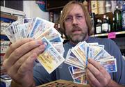 Jeff Jensen, owner of Jensen Liquor, 620 W. Ninth, gets a rush of
customers using fake ID's this time of year. Thursday he displayed
about 40 of the bogus ID's confiscated at his store since the
beginning of July.