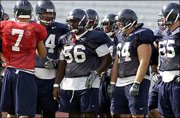 Kansas University offensive linemen, front row from left, David
Ochoa, Joe Vaughn, Nick McCaslin and Matt Thompson listen to
quarterback Adam Barmann (7). The Jayhawks had an open practice
Friday at Memorial Stadium.